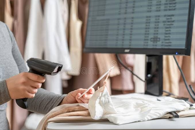 Barcodescanner scant het label van een kledingstuk aan de kassa
